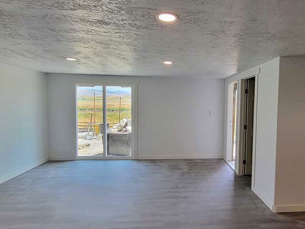 Spacious modern living room with sliding glass doors and scenic mountain view.